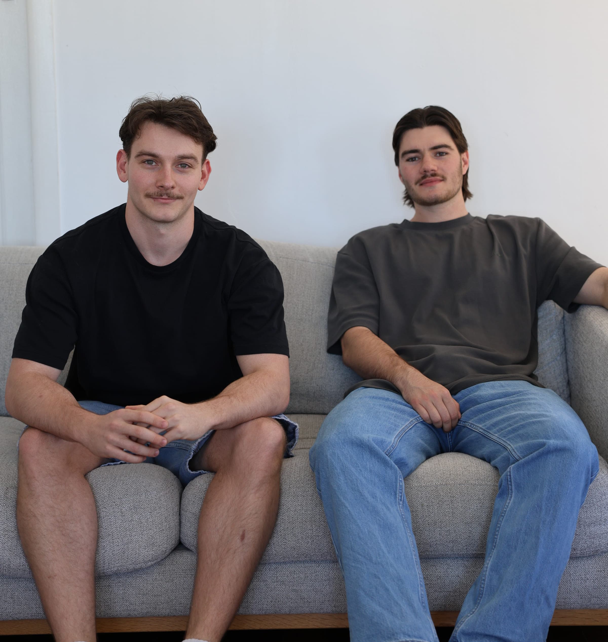 Studio Parallel co-founders Joe and Hayden sitting together on a sofa in the studio